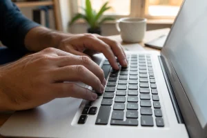 Gros plan sur un clavier MacBook AZERTY montrant l'emplacement du trait d'union près de la touche zéro
